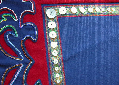 "TakDeinTaan" Button blanket robe  Close up of beadwork (by Irene Lampe), carved mother-of-pearl buttons, and braid